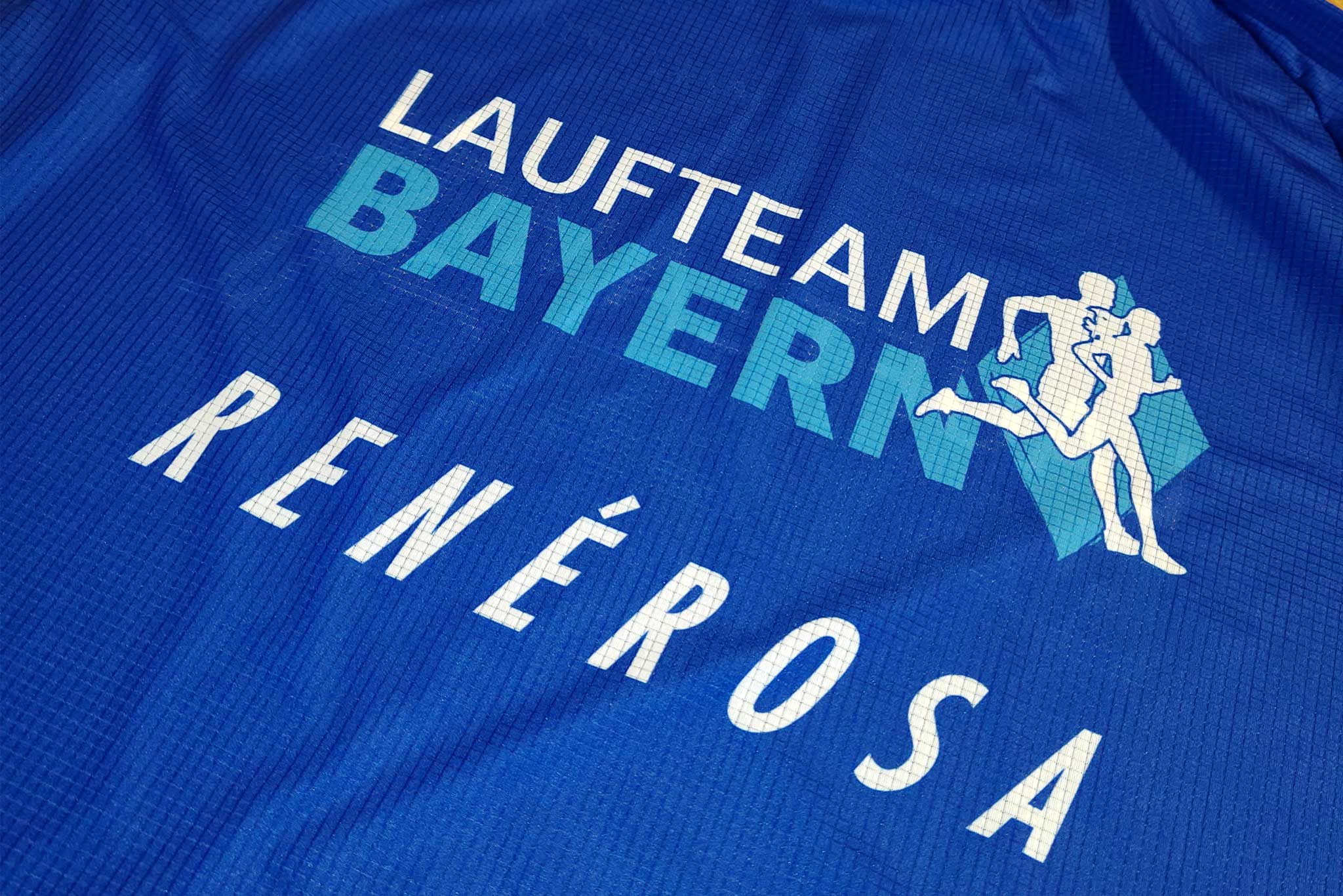 Die Logos von Laufteam Bayern und unserem Exklusivausrüster RenéRosa auf einem Raceshirt.